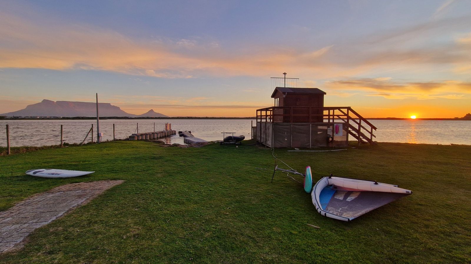 Abendstimmung am Rietvlei: Wing und Board auf der Wiese des Milnerton Aquatic Club, dahinter der Tafelberg